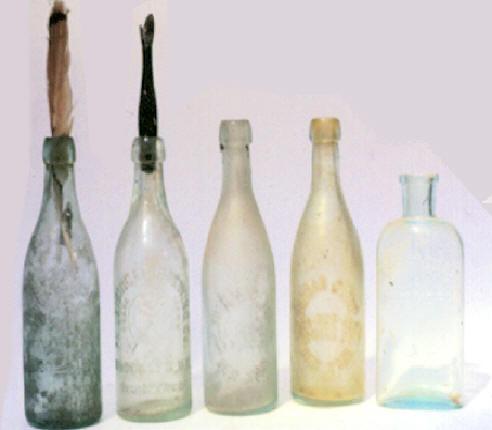 A House bottle holds a doll’s carved wooden arm.